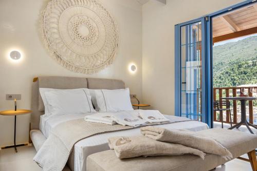 a bedroom with a bed with towels on it at Tellion Suites in Lefkada Town