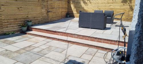 a patio with two chairs and a table at Viaduct View - Cefn Coed in Merthyr Tydfil