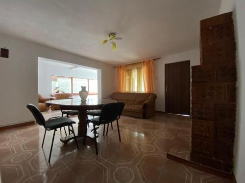 a living room with a table and chairs and a couch at Casa Carmen in Tîrgu Ocna