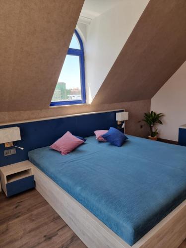 サニービーチにあるComplex Astraのベッドルーム1室(ピンクとブルーの枕が付いた青いベッド1台付)