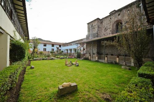 a group of animals sitting on the grass in a courtyard at Hotel Monasterio San Pedro in Cusco