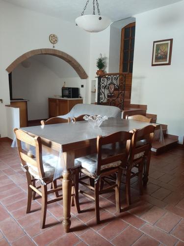 un soggiorno con tavolo e sedie in legno di Casa Zeno a Volterra
