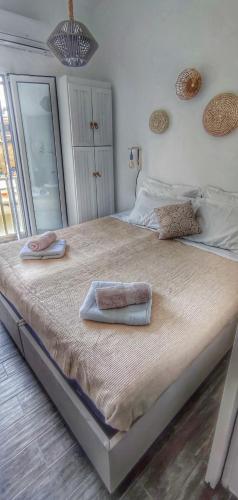 un grande letto con due asciugamani sopra di Shades a Città di Skiathos