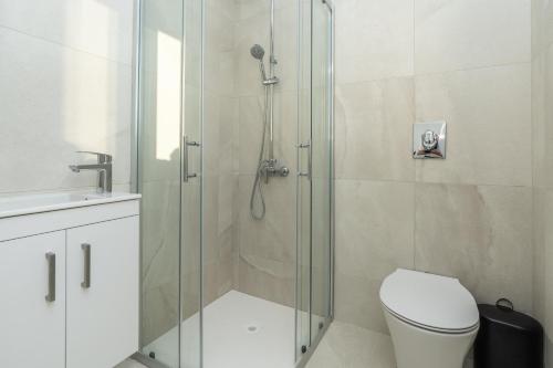 a bathroom with a shower with a toilet and a sink at Tsiolakki Homes Luxury Villas in Protaras