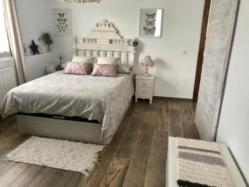 a bedroom with a bed with pink pillows and a mirror at CASA NATURAE in Pineda de la Sierra