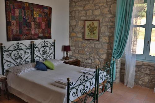 ein Schlafzimmer mit einem Bett und einer Steinmauer in der Unterkunft Relais Maffia B&B in Orsara di Puglia