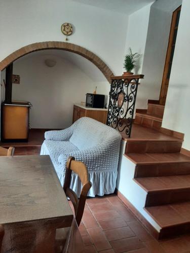 a living room with a table and stairs in a house at Casa Zeno in Volterra