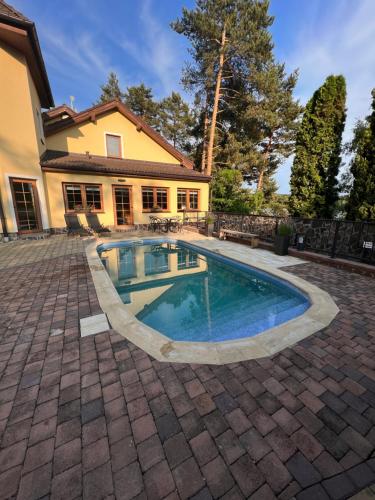 a swimming pool in front of a house at Resort-Restaurant Stilec in Kamenný Újezd