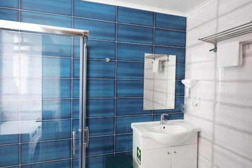 a blue tiled bathroom with a sink and a shower at Apartment Ajuda Tagus (ground floor) in Lisbon
