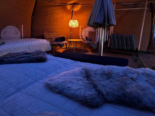a bedroom with a bed with a purple blanket at Romantic Luxus Glamping 3 in Idestrup
