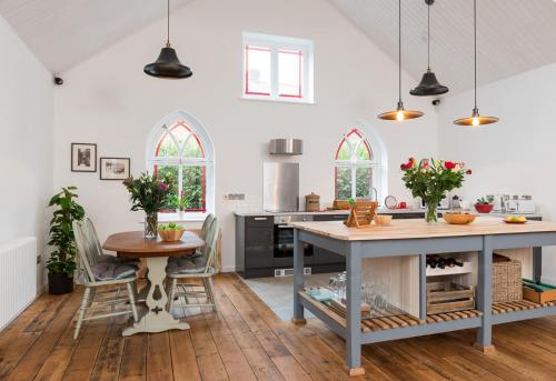 an open kitchen with a table and a dining room at CHESTER'S ONLY TIN CHAPEL - UNIQUE, SPACIOUS 2 BEDROOMS, GARDEN AND FREE PARKING in Chester