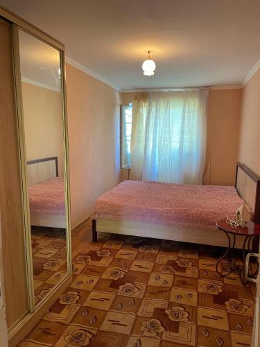 a bedroom with two beds and a mirror at Апартаменты Инал-ипа 10 in Sukhum