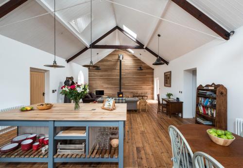 an open kitchen and living room with wooden ceilings at CHESTER'S ONLY TIN CHAPEL - UNIQUE, SPACIOUS 2 BEDROOMS, GARDEN AND FREE PARKING in Chester