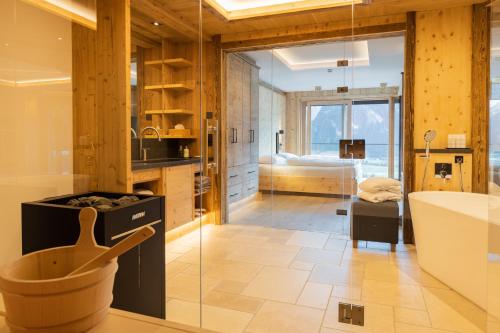 a bathroom with a tub and a sink and a bath tub at Chalet Residenz Zillertal Mühlermoos in Ramsau im Zillertal