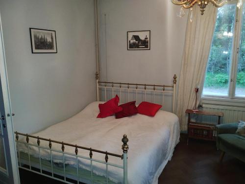 um quarto com uma cama com almofadas vermelhas em Peaceful Pernaja em Garpgård