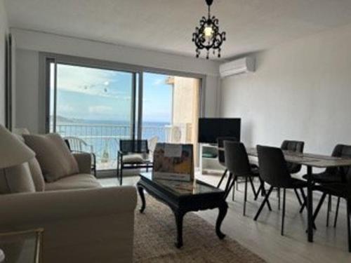 un salon avec un canapé et une table avec des chaises dans l'établissement Appart 2p/cabine 6 pers à 200m plage Banyuls-sur-Mer, clim, parking, vue imprenable - FR-1-225C-530, à Banyuls-sur-Mer