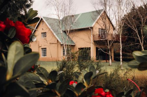 uma casa grande com um telhado verde em Copperleigh Trout Cottages em Dargle