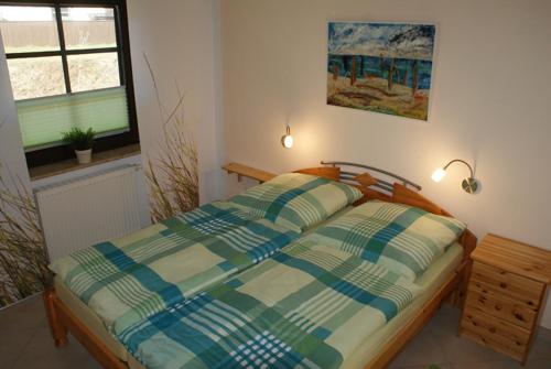 um quarto com uma cama e uma janela em Zum Froschkönig em Ahrenshoop