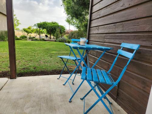 a blue table and two chairs on a patio at Casa Gila in Yonatan