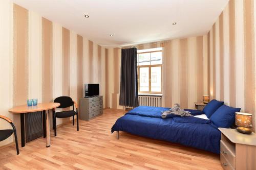 Un dormitorio con una cama azul y una mesa en Telegrafs, en Ventspils
