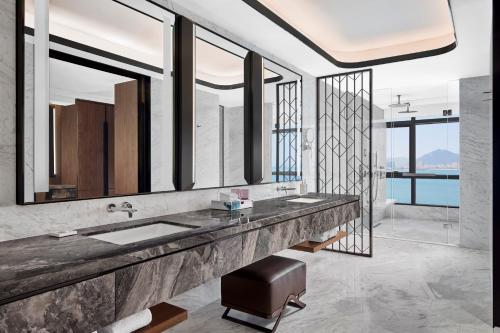 a bathroom with a sink and a large mirror at Courtyard by Marriott Xiamen in Xiamen
