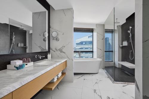 a bathroom with a tub and a sink and a shower at Courtyard by Marriott Xiamen in Xiamen