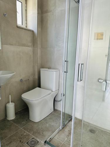 a bathroom with a toilet and a glass shower at Cost Mari Almyrida New by ZAGO Boutiqe hotels in Almirida