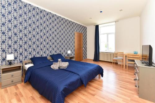 a bedroom with a blue bed and a television at Telegrafs in Ventspils