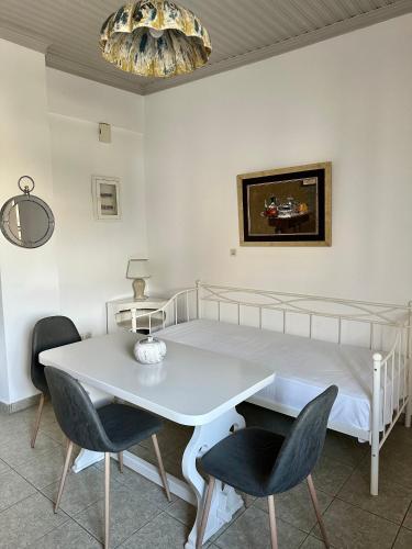 a bedroom with a bed and a white table and chairs at Balcony of Koroni in Koroni