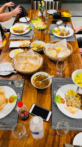 a long wooden table with plates of food on it at Spring Villas Kandy in Kandy