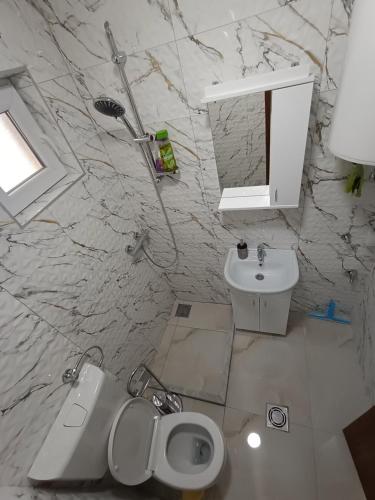 a white bathroom with a sink and a toilet at stan na dan IM in Užice