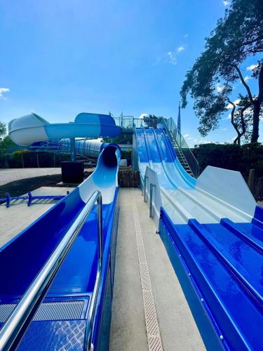 un toboggan dans un parc avec un train bleu dans l'établissement Grand mobil home exposé sud, 2 salles de bain, à Onzain