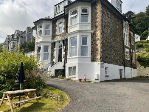 a picnic table in front of a large house at Cairn House in Ilfracombe