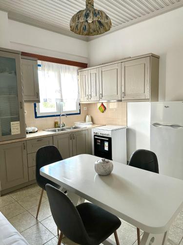 a kitchen with a table and chairs and a white refrigerator at Balcony of Koroni in Koroni