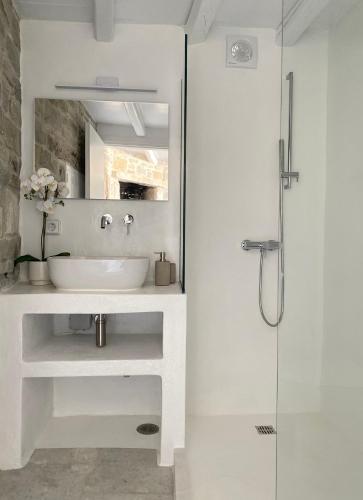 a white bathroom with a sink and a shower at Aegean Breeze House in Kampos Paros