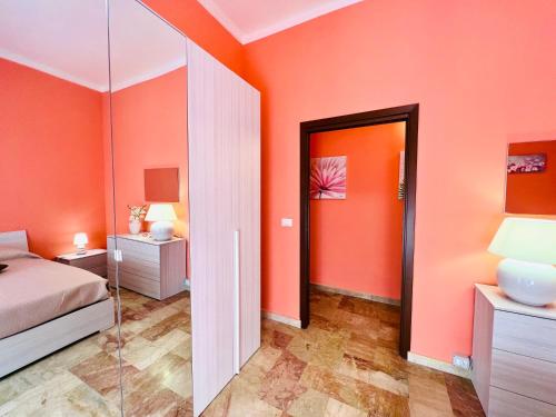 a bedroom with orange walls and a bed and a mirror at Domus Aurea in Isola delle Femmine