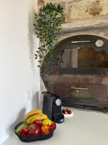 a bowl of fruit on a counter next to a toaster at Aegean Breeze House in Kampos Paros