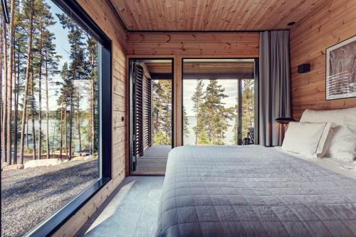 a bedroom with a large window and a bed at Saunamäki Resort - Lux Villa in Salo