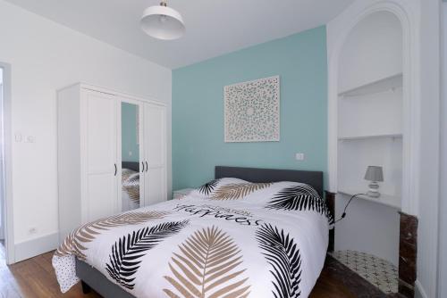 1 dormitorio con 1 cama con pared azul en LE PALAIS DES THERMES, en Nancy