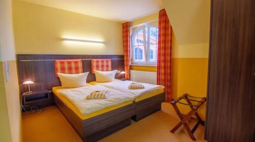 Schlafzimmer mit einem Bett und einem Fenster in der Unterkunft Hotel Strandburg Prerow in Prerow