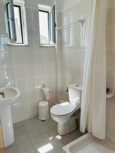 a white bathroom with a toilet and a sink at Cost Mari Almyrida New by ZAGO Boutiqe hotels in Almirida