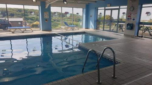 a large swimming pool in a building at Holiday Lodge, sleeps 4, with sea & countryside views in Ore