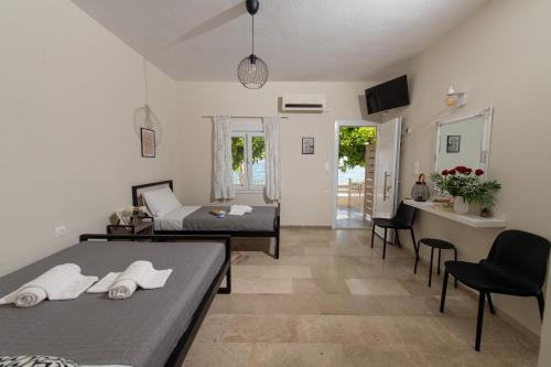 un soggiorno con 2 letti e un tavolo di Moukas Seaside Apartments Romantico a Selianitika