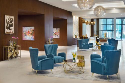 a lobby with blue chairs and a waiting room at Le Méridien City Center Doha in Doha