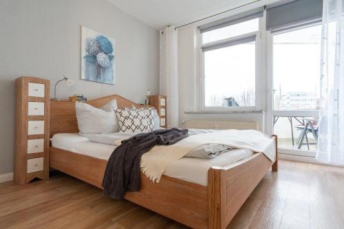 een slaapkamer met een houten bed en een raam bij Haus-des-Kurgastes-Wohnung-4 in Heiligenhafen