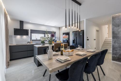 a dining room and kitchen with a table and chairs at Villa ToDo with heated pool and jacuzzi in Vinišće