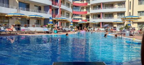 een zwembad in een hotel met mensen in het water bij Central Plaza - Studio - Sunny Beach in Sunny Beach