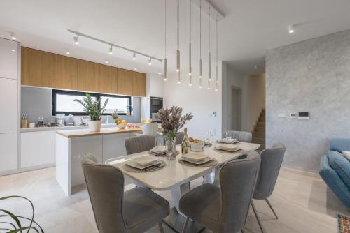 a dining room and kitchen with a table and chairs at Villa ToDo with heated pool and jacuzzi in Vinišće