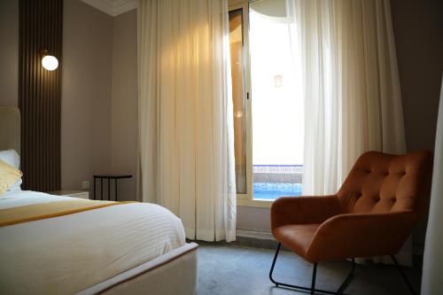 - une chambre avec un lit, une chaise et une fenêtre dans l'établissement شاليهات أندلوسيا, à Riyad