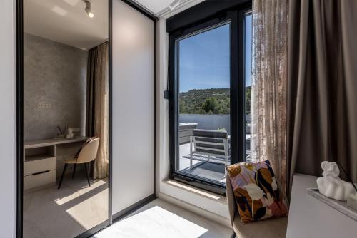 a room with a large window with a desk and a chair at Villa ToDo with heated pool and jacuzzi in Vinišće